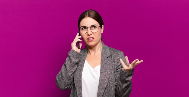 Jonge mooie vrouw die haar lege schermtelefoon toont.