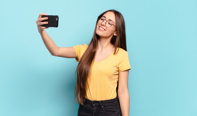 Jonge mooie vrouw die haar mobiel gebruikt.