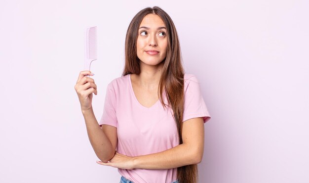 Jonge mooie vrouw die haar schouders ophaalt, zich verward en onzeker voelt. haar kam concept