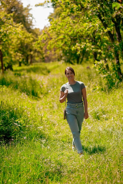 Jonge mooie vrouw die in het bos loopt