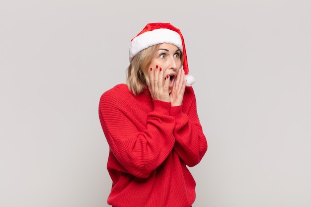 Jonge mooie vrouw die Kerstmiskleren draagt