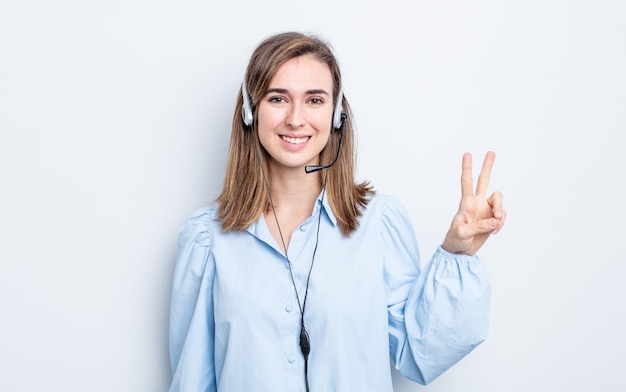 Jonge mooie vrouw die lacht en er vriendelijk uitziet, met nummer twee. telemarketeer concept