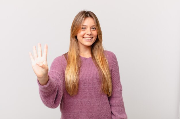 Jonge mooie vrouw die lacht en er vriendelijk uitziet, met nummer vier