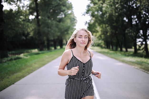 jonge mooie vrouw die langs de bosweg loopt