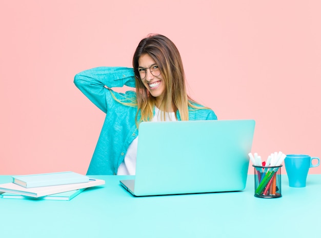 Jonge mooie vrouw die met laptop werkt die vrolijk en vol vertrouwen met een toevallige, gelukkige, vriendelijke glimlach lacht