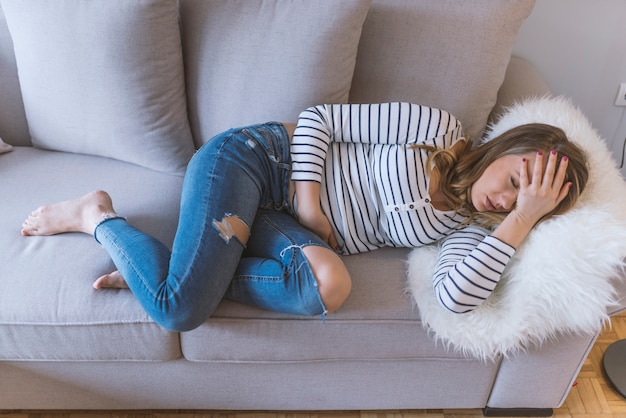 Jonge mooie vrouw die pijnlijke maagpijn heeft