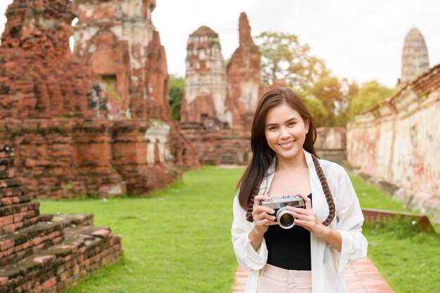 Jonge mooie vrouw die reist en foto's neemt in het Thaise historische Park