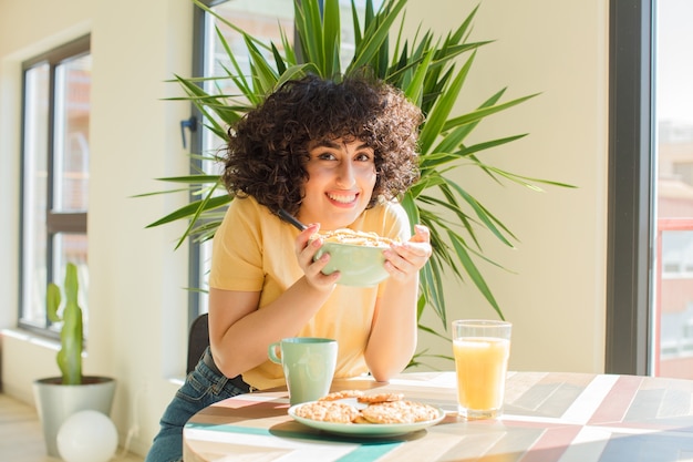 Jonge mooie vrouw die thuis ontbijt