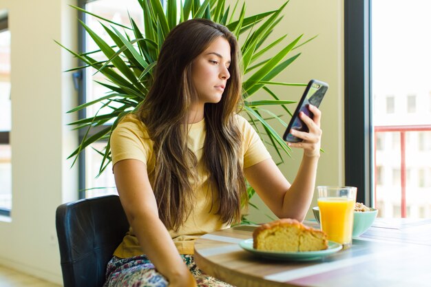 Jonge mooie vrouw die thuis ontbijt