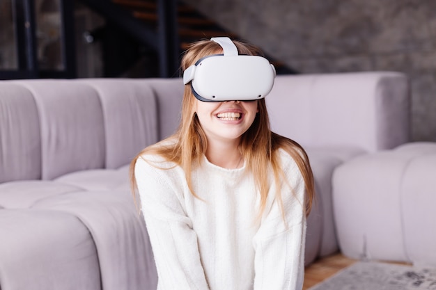 Jonge mooie vrouw die thuis vr-games speelt in virtual reality-bril