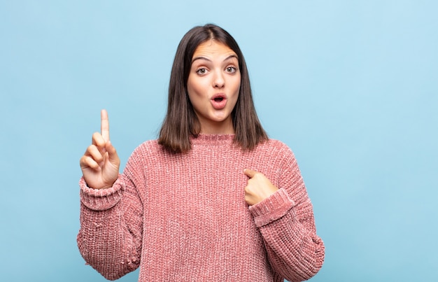 Jonge mooie vrouw die trots en verrast is, zelfverzekerd naar zichzelf wijst, zich succesvol nummer één voelt