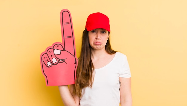 Foto jonge mooie vrouw die verdrietig en zeurt met een ongelukkige blik en huilend nummer één handconcept