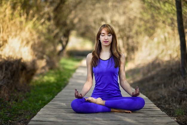 Jonge mooie vrouw die yoga in aard doet