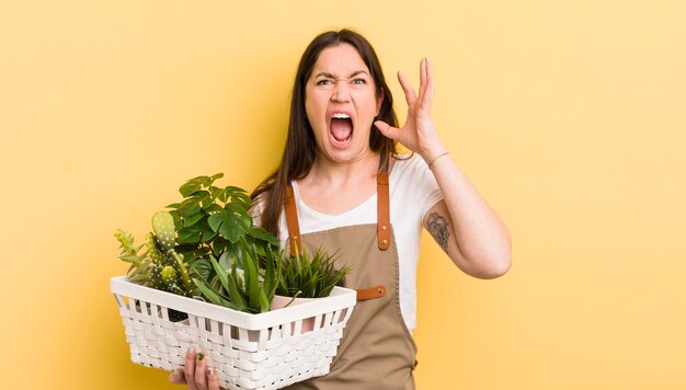 Jonge mooie vrouw die zich gelukkig voelt en een uitdaging aangaat of het plantenconcept viert