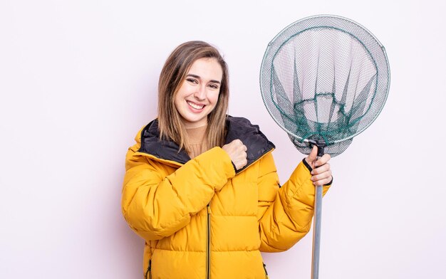 Jonge mooie vrouw die zich gelukkig voelt en een uitdaging aangaat of viert. visser concept