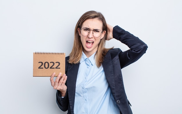 Foto jonge mooie vrouw die zich gestrest, angstig of bang voelt, met de handen op het hoofd. kalender concept