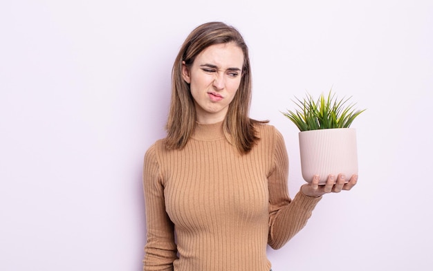 Jonge mooie vrouw die zich verdrietig, overstuur of boos voelt en opzij kijkt. plant concept