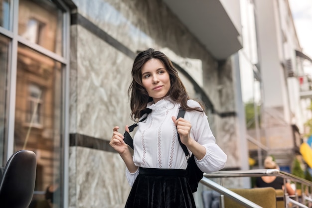 Jonge mooie vrouw die zich voordeed op modern gebouw, zomertijd voor vakantie