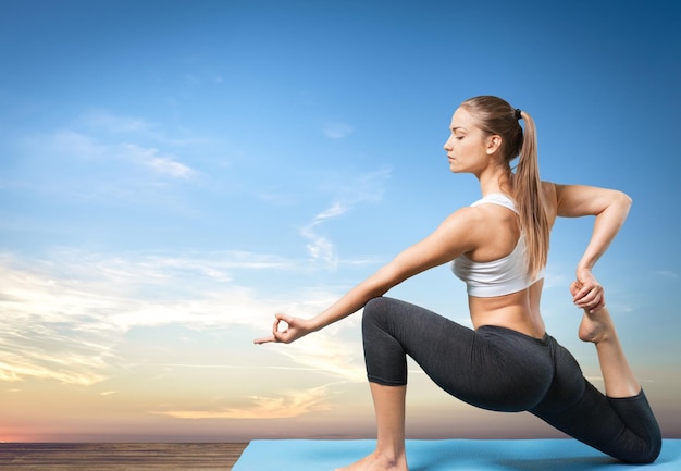 Jonge mooie vrouw doet yoga op de achtergrond