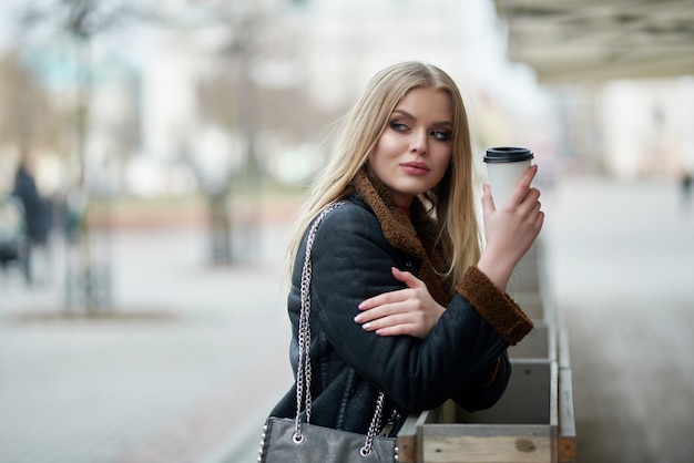 Jonge mooie vrouw drinken koffie en wandelen door de stad