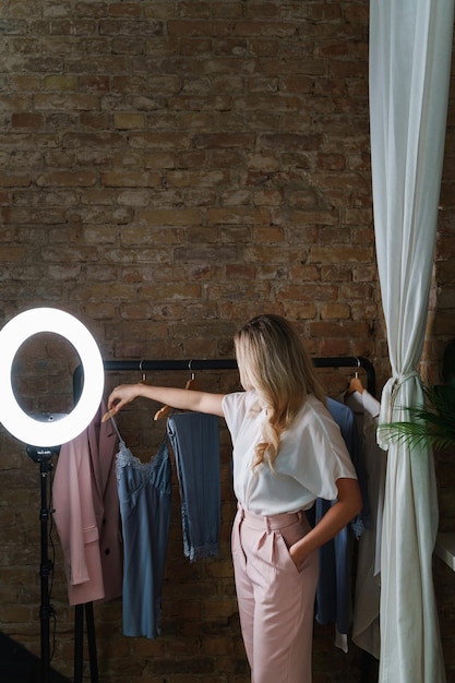 Jonge mooie vrouw en kledingrek met verschillende outfits