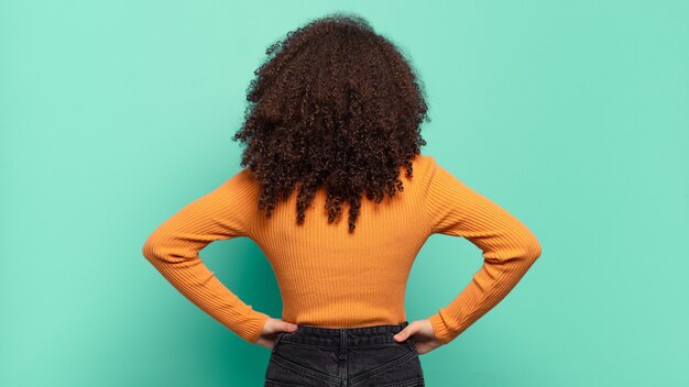 Jonge mooie vrouw gebaren op gekleurde muur