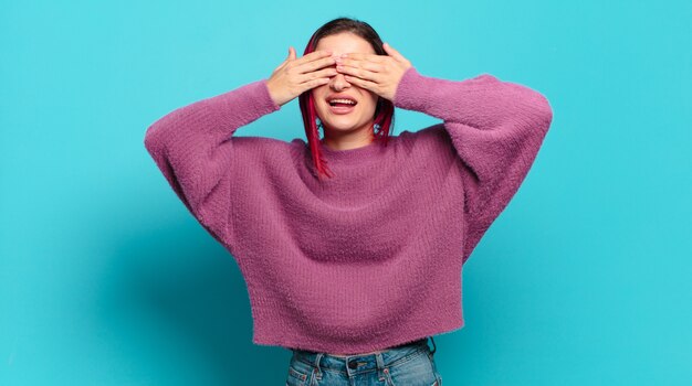 Jonge mooie vrouw gebaren op gekleurde muur