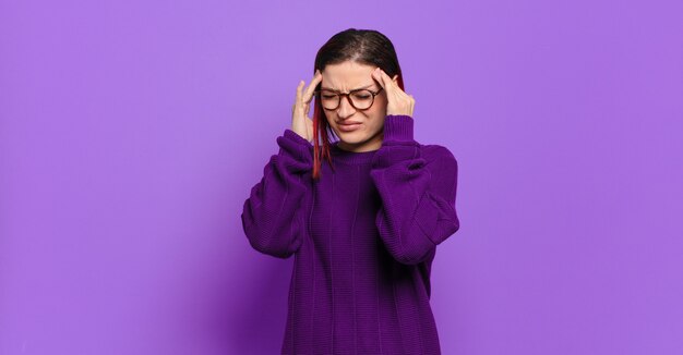 Jonge mooie vrouw gebaren op gekleurde muur