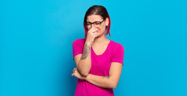 Jonge mooie vrouw gebaren op gekleurde muur