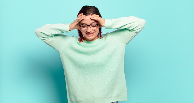 Jonge mooie vrouw gebaren op gekleurde muur