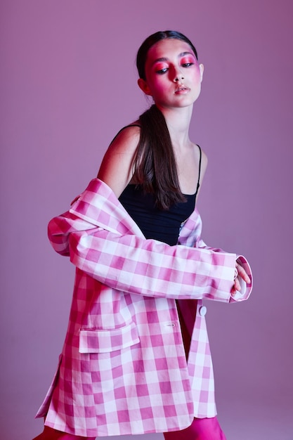 Jonge mooie vrouw geruite blazer mode poseren luxe roze achtergrond ongewijzigd