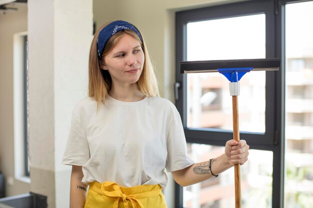 Jonge mooie vrouw glimlachend en kijkend met een gelukkig zelfverzekerd expressie windows wasmachine concept