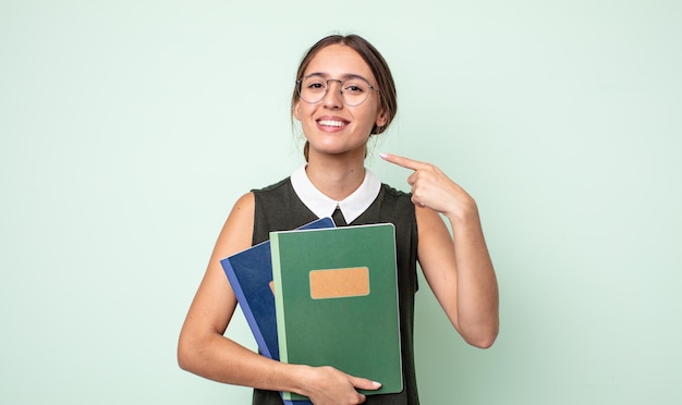 Jonge mooie vrouw glimlachend vol vertrouwen wijzend naar eigen brede glimlach. universitair concept