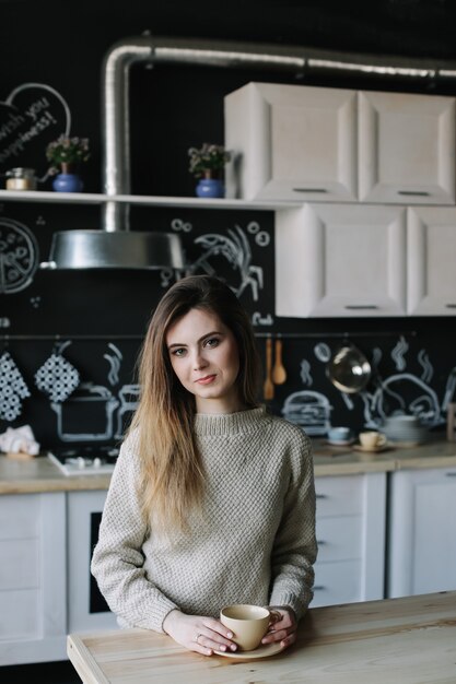 Jonge mooie vrouw in de keuken thuis