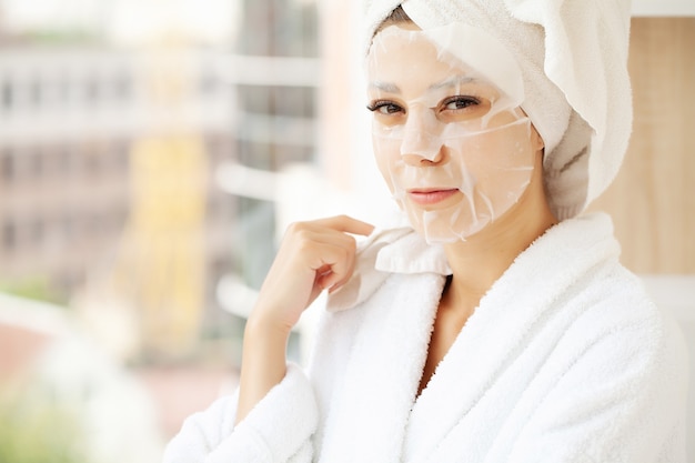 Jonge mooie vrouw in een gezichtsmasker, huidzorg.