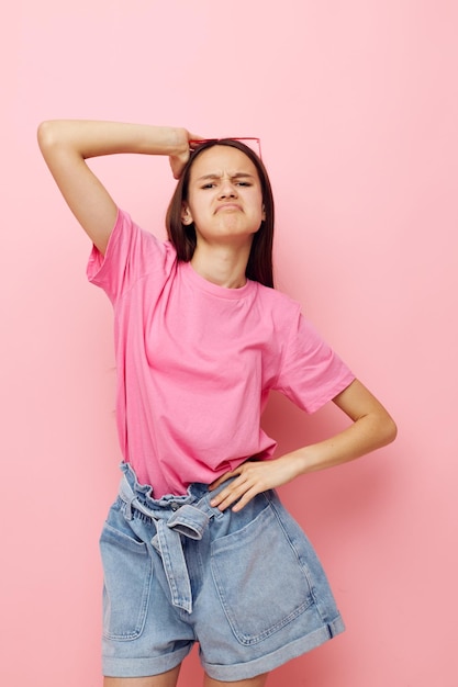 Jonge mooie vrouw in een roze tshirt casual kleding roze achtergrond