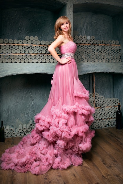 jonge mooie vrouw in lange roze jurk