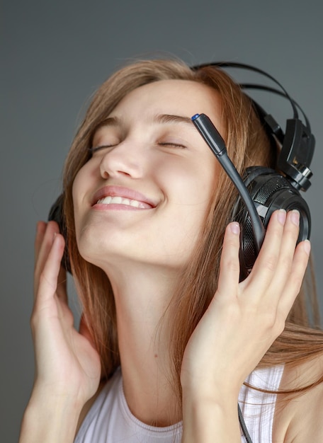 Jonge mooie vrouw in lichte outfit genieten van de muziek thuis