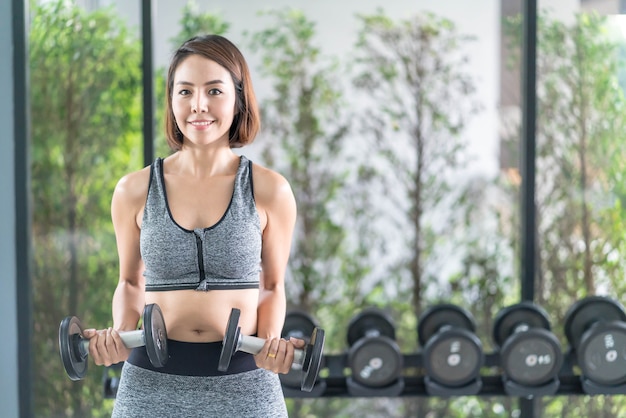 Jonge mooie vrouw in sportkleding uit te werken in de sportschool