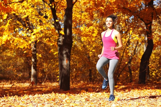 Jonge mooie vrouw joggen in herfst park