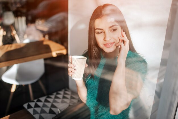 Jonge mooie vrouw koffie drinken in café-bar