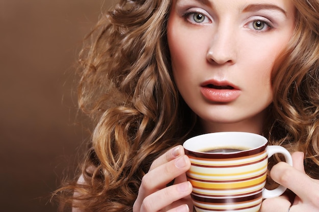 Jonge mooie vrouw koffie drinken