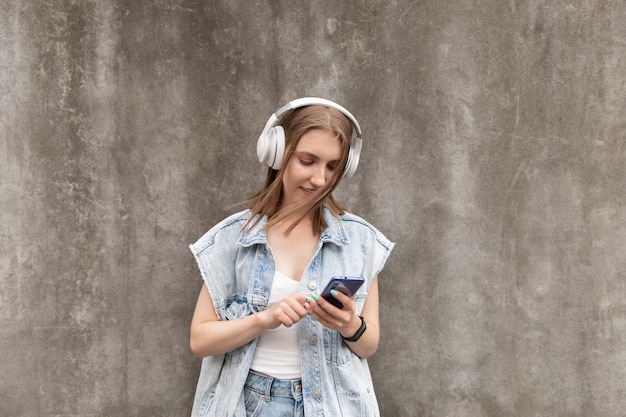 Jonge mooie vrouw luistert muziek op koptelefoon.