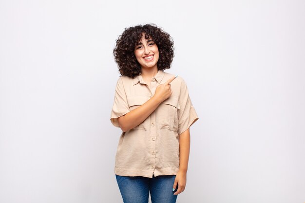 jonge mooie vrouw met afrohaar wijzend naar de zijkant