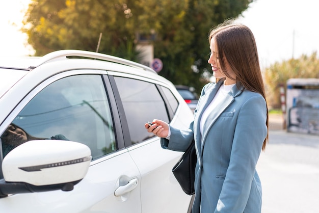 Jonge mooie vrouw met autosleutels buitenshuis