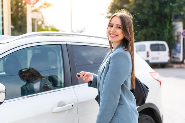 Jonge mooie vrouw met autosleutels buitenshuis