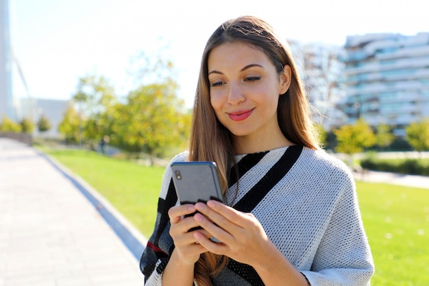 Jonge mooie vrouw met behulp van een smartphone