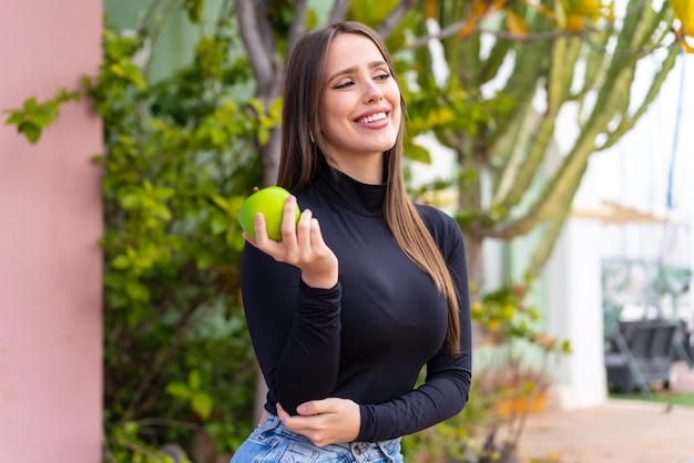 Jonge mooie vrouw met een appel in de open lucht