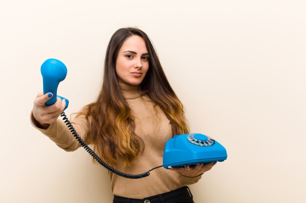 Jonge mooie vrouw met een blauwe vintage telefoon