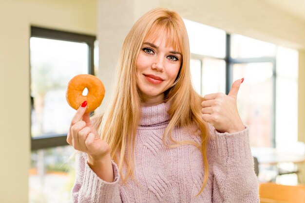 Jonge mooie vrouw met een donut ongezond dieet concept thuis interieur